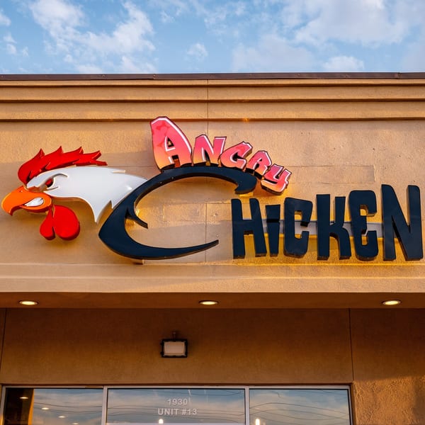 The Angry Chicken restaurant sign, featuring a stylized chicken head and bold red and black lettering.