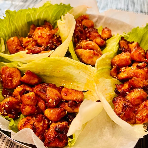 Angry Chicken's fried chicken lettuce wraps, with crispy chicken pieces and sesame seeds.